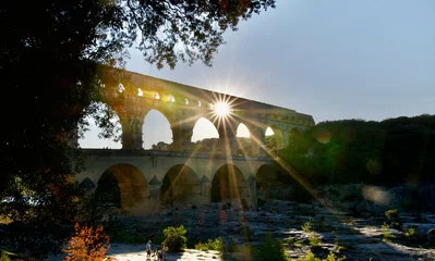 Papier Peint photo Pont du Gard The Magnificent roman Pont du Gard bridge crossed by the rays of the sunset in summer in the south of France. It is also an aqueduct.