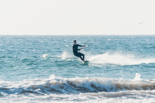 young latino practicing kitesurfing in the pacific ocean