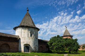 Fototapeta premium The courtyard of the Kremlin in Yuriev-Polsky in Russia with ancient architecture on bright green grass on a sunny summer day and a space for copying