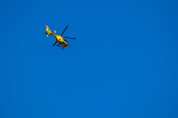 yellow helicopter in the blue sky
