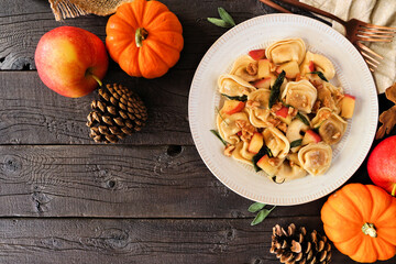 Fall pumpkin and apple tortellini pasta with walnuts and brown butter sage sauce. Overhead view...