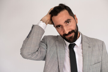 Portrait of gorgeous bearded man. Male model in suit against white background, touching head. Portrait, studio shot concept