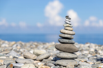 Fototapeta na wymiar Pebble tower balance harmony stones arrangement on sea beach coastline