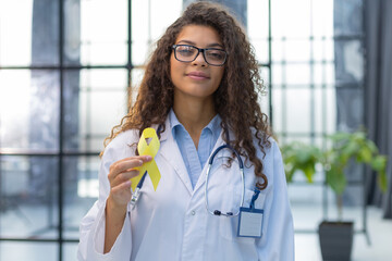 Doctor in a white uniform holds a yellow ribbon in her hand, symbol of the fight against the cat's...