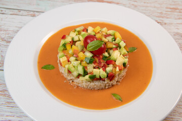 Vegan salad recipe based on bulgur with small vegetables, avocado, tomato, cucumber, pepper, nectarine fruit, tomato basil sauce and olive oil and lemon