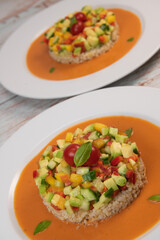 Vegan salad recipe based on bulgur with small vegetables, avocado, tomato, cucumber, pepper, nectarine fruit, tomato basil sauce and olive oil and lemon