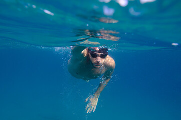 Fototapeta na wymiar Sporty man swims fast in the sea
