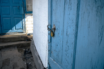 Old wooden barn door with a padlock. Padlock on an old blue wooden door