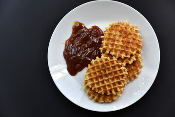 Delicious Viennese waffles with jam on a white plate. A sweet breakfast of Viennese waffles.