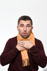 Obraz premium A man suffers from a sore throat, a man wrapped his throat with a scarf, portrait on a white background.