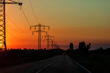 Fototapeta na wymiar Electric power pylon, electric tower at sunset