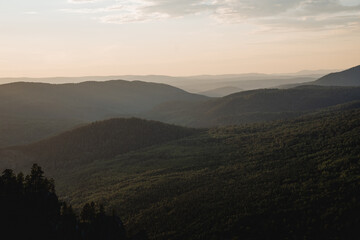 Landscape at dusk from a bird's eye view, photo from a drone, Russian taiga, foggy horizon, a lot of forest, coniferous trees.