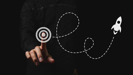 A businessman launches a space rocket as a symbol of a successful business start. Choosing a...