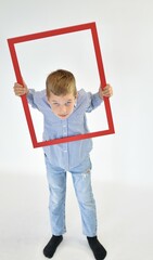 boy in a striped suit and a red wooden frame on a white background