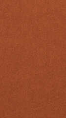 Dark orange colored paper texture. Bright brown vertical background. Mobile phone wallpaper. Textured surface, fibers and irregularities are visible. Top-down