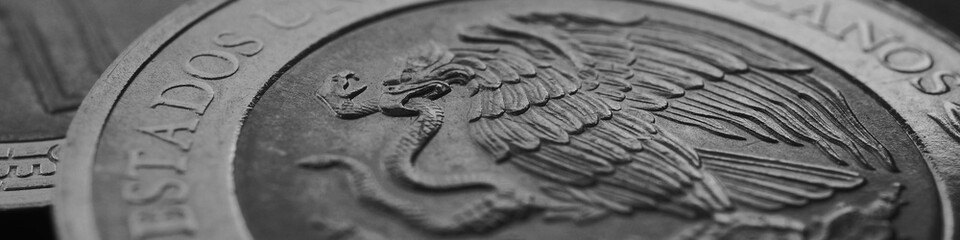 Coin of 5 five Mexican pesos closeup. Peso of Mexico. Reverse of coin with coat of arms of country. Eagle and snake. Black and white banner. News about economy or banking. Credit and money. Macro