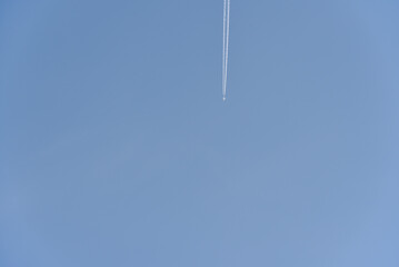 The contrail of an airplane in the blue sky. The flight of a passenger plane.