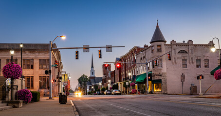 Scarce traffic on Main Street in downtown Woodford county's Versailles, KY during sunrise - obrazy, fototapety, plakaty