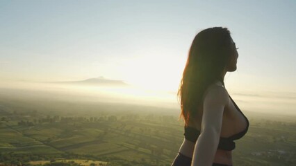 Silhouette of strong confidence woman open arms under the sunrise