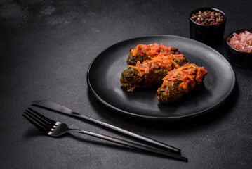 Dolma, stuffed grape leaves with rice and meat on a dark background