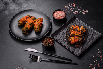 Dolma, stuffed grape leaves with rice and meat on a dark background