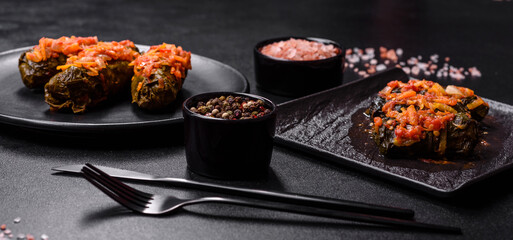 Dolma, stuffed grape leaves with rice and meat on a dark background