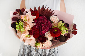 Woman with  bouquet of flowers. Beautiful flowers for  holiday. Woman with beautiful flowers in her hands indoors background.  bouquet of flowers for  flower shop.