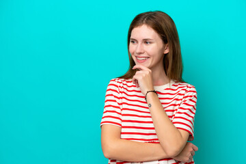 Young English woman isolated on blue background looking to the side and smiling