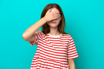 Young English woman isolated on blue background covering eyes by hands. Do not want to see something
