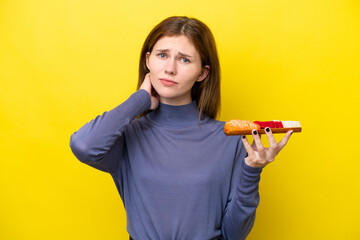 Young English woman holding sashimi isolated on yellow background having doubts