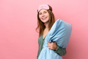 Young English woman in pajamas isolated on pink background in pajamas and smiling a lot