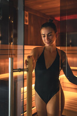 A young woman having rest in sauna alone.
