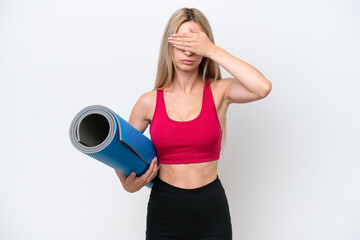 Young sport blonde woman going to yoga classes while holding a mat isolated on white background covering eyes by hands. Do not want to see something