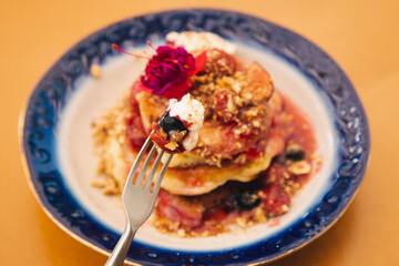 Appetizing pancakes decorated with berries and flowers.