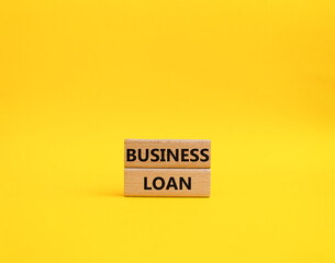 Business loan symbol. Concept words business loan on wooden blocks. Beautiful yellow background. Business and business loan concept. Copy space.