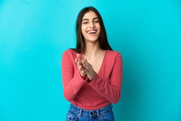 Young caucasian woman isolated on blue background applauding after presentation in a conference