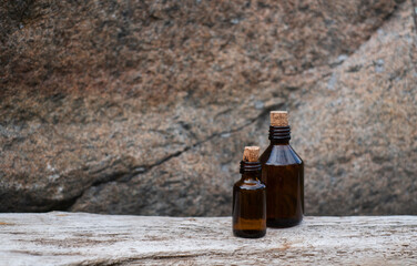 Obraz na płótnie Canvas Small brown glass medicine bottle on aged wood background. Essential oil. 