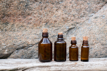Small brown glass medicine bottle on aged wood background. Essential oil. 
