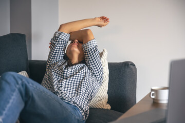 Fototapeta premium Tired from work young woman in front of a laptop.