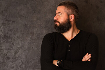 A young man with a beard on a dark background