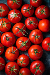 Many fresh red tomatoes on a dark green background. Top view