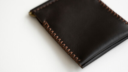Brown money clip handmade from genuine leather on white surface.