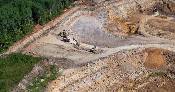 Bagger und Lastwagen arbeiten an einem Sandsteinbruch