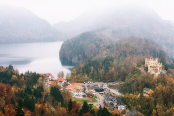 View on  Hohenschwangau castle, the lake near it and the mountain slopes are covered with autumn trees. Popular tourist attraction. Bavaria, Germany, Europe.