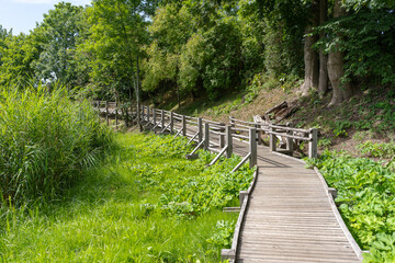 Wooden footpath along a small river.