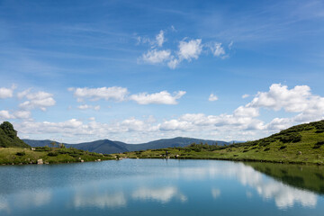Fototapeta na wymiar The water surface of a calm lake Vorozhesku against the background of the Gorgan mountain range