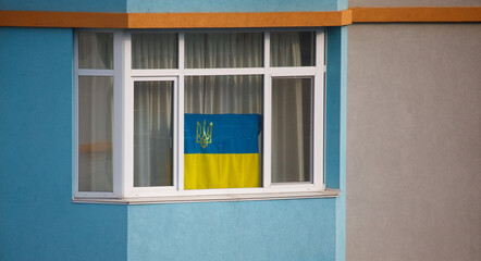 flag of Ukraine on the window of the house
