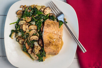 baked season salmon with a side of sauteed spinach and mushrooms