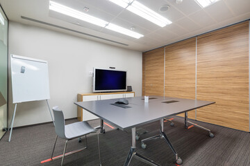 Fototapeta na wymiar Office meeting room with light walls, gray carpet and furniture.
