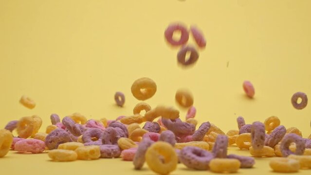 Bowl with multi-colored cornflakes slowmotion